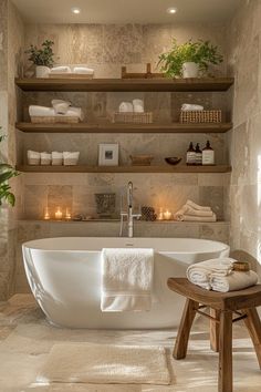 a large white bath tub sitting next to a wooden stool in a room with shelves on the wall