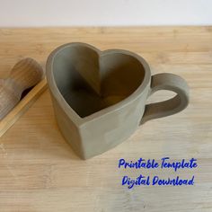 a heart shaped ceramic cup sitting on top of a wooden table