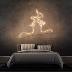 a bed in a room with a neon sign above it