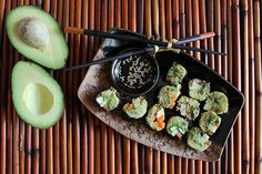 an avocado and some kind of food on a plate with chopsticks