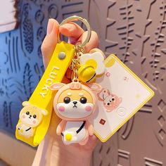 a person holding a keychain with some cute animals on it