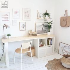 a white desk and chair in a room with pictures on the wall behind it,