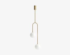 two white balls hanging from a brass colored light fixture on a white wall with no one in it