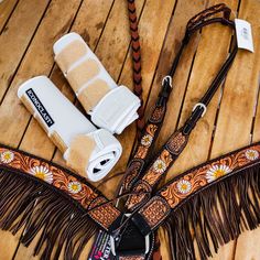 a pair of white boots sitting on top of a wooden floor next to a brown fringe