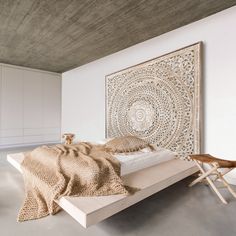 a bedroom with a bed, chair and artwork on the wall above it in an apartment