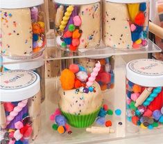 cupcakes and candy in jars on display for sale at a store or party