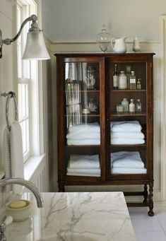 a bathroom with marble counter tops and white towels on the shelves in front of it