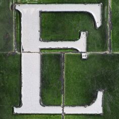 the letters e and f are made out of cement blocks in grass, with one letter on each side