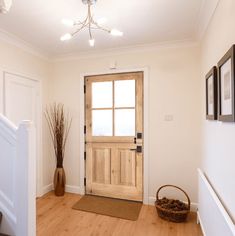 an entryway with a wooden door and basket on the floor