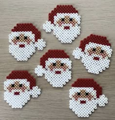 six pixelated santa claus coasters sitting on a table with white and red dots