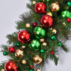 a christmas tree with red, green and gold ornaments hanging from it's branches