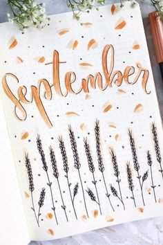 an open notebook with the word november written in cursive writing on it next to some flowers