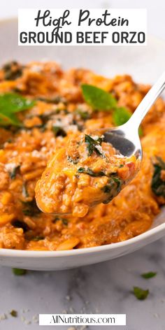 a white bowl filled with rice and spinach covered in grated beef orzo