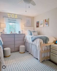 a bed room with a neatly made bed and a laptop on the desk next to it