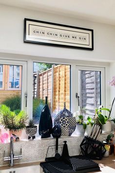 a kitchen counter with pots and vases on the window sill next to it