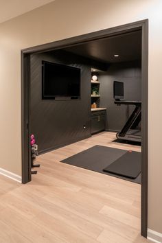 a home gym with an exercise mat and television