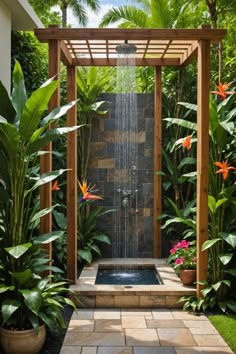 an outdoor shower surrounded by tropical plants and flowers