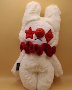 a white stuffed animal with red eyes and a bow tie around it's neck