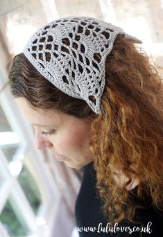 a woman with red hair wearing a white crochet hat