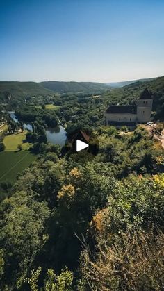 an aerial view of a house in the middle of a forest with a river running through it