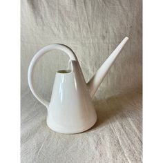 a white teapot with a long handle on a white background, it looks like the tip of a watering can