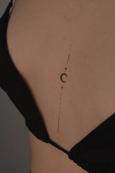 the back of a woman's stomach with a crescent tattoo on it