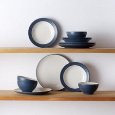 plates and cups are arranged on the shelf in front of each other, including one blue