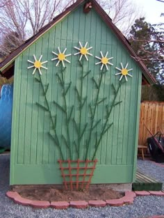 a green shed with daisies painted on the side