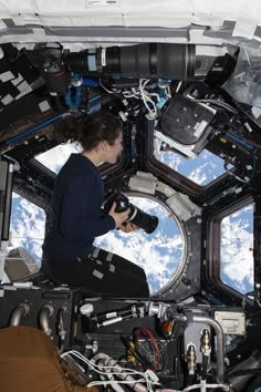 a woman sitting in the window of a space station