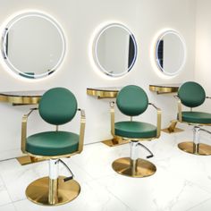 there are three chairs in the room with mirrors on the wall and one is green