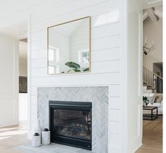 a white fireplace with a mirror above it