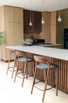 a kitchen island with four stools next to it