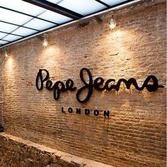 the entrance to pro jesmo london with brick wall and sign on it's side