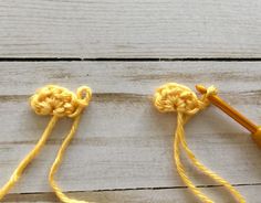 two crochet hooks with yellow yarn on them