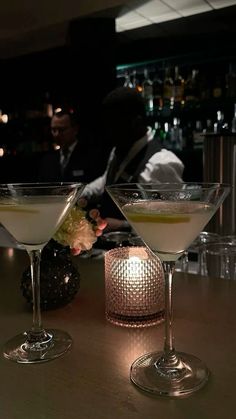 two martini glasses sitting on top of a table