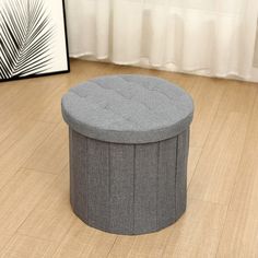 a round ottoman sitting on top of a hard wood floor