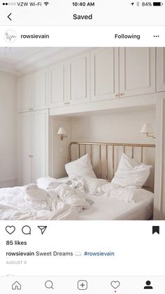 an instagramted photo of a bed with white linens and pillows on it