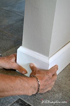 an older person is holding the corner of a wall