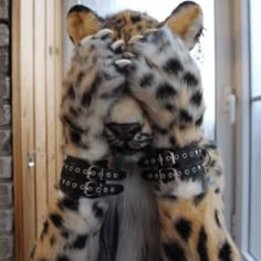 a stuffed animal that is standing up in front of a door with its head covered by chains