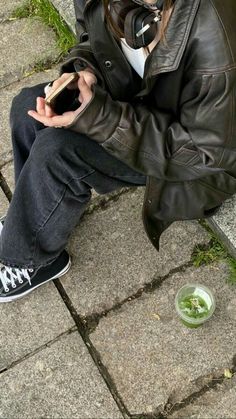 a person sitting on the ground using their cell phone