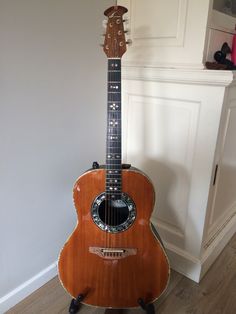 an acoustic guitar sitting on top of a stand