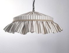 a striped lamp hanging from a metal chain