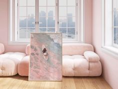 a living room with pink walls and white couches in front of a painting on the floor