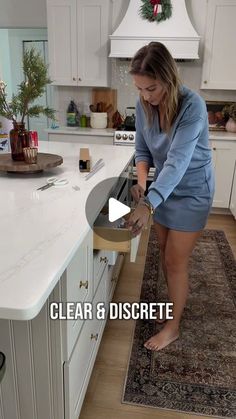 a woman in a blue dress is opening a dishwasher