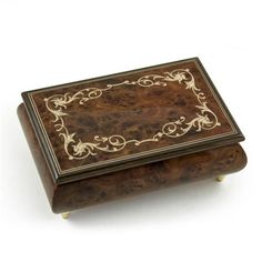 a wooden box with an ornate design on the front and sides, sitting on a white surface