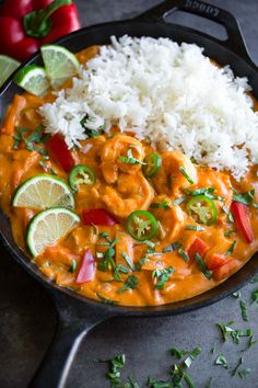 a skillet filled with shrimp, rice and cilantros on top of a table