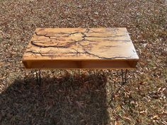 a wooden table sitting on top of dry grass