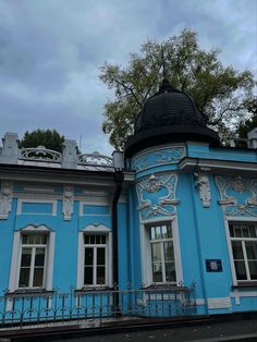 a blue building with white trim and windows