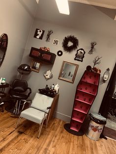 a hair salon with chairs, mirrors and pictures on the wall above it's shelves