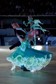 two people on a dance floor with their arms around each other